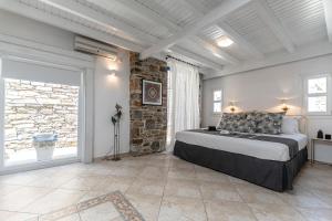 1 dormitorio con 1 cama grande y pared de piedra en Casa Solmar, Stelida Naxos, by NaxosVibe en Stelida