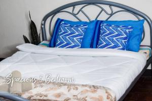 uma cama com almofadas azuis e brancas em 5 Bedrooms 4 Bath/toilet & Mountain View Fast Net em Baguio