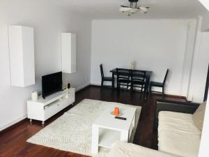 a living room with a couch and a tv and a table at Ana-Maria Home in Râmnicu Vâlcea