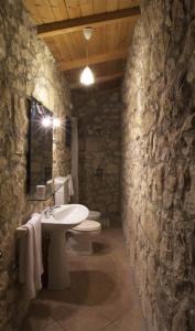 bagno in pietra con lavandino e servizi igienici di Trullo in the Wood a Nardò