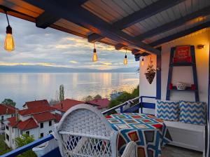 a balcony with a table and chairs and a view of the water at Villa Forest Paradise in Ohrid