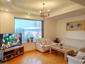 ein Wohnzimmer mit einem Sofa und einem TV in der Unterkunft Villa Forest Paradise in Ohrid