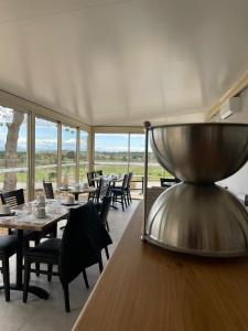 un comedor con mesas, sillas y ventanas en Château Catherine de Montgolfier B&B, en Narbona