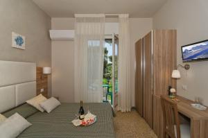 una camera con un letto e un tavolo con bottiglie di vino di Hotel Giardino a Lido di Camaiore