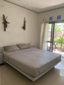 duże łóżko w sypialni z oknem w obiekcie Bintang Guesthouse w Gili Trawangan