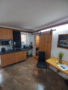 cocina con armarios de madera, mesa y escritorio en Pferdehof Reitingau en Mautern in Steiermark