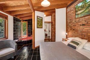um quarto com uma parede de tijolos, uma cama e um sofá em Salisbury Lodges em Salisbury