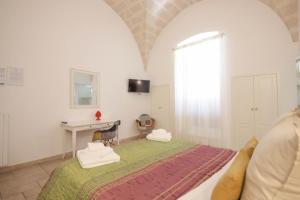 a bedroom with a bed and a desk and a window at Sogno D'Epoca 1822 in Monopoli