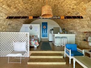 ein Wohnzimmer mit 2 Stühlen und eine Küche in der Unterkunft Le Blanc Bleu in Byblos