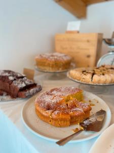 una mesa cubierta con diferentes tipos de pasteles y tartas en Regina Margherita B&B, en Marzamemi