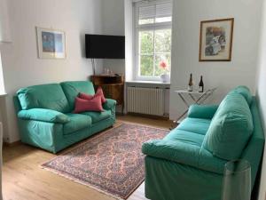 un soggiorno con divano verde e tappeto di Darling Home a Merano