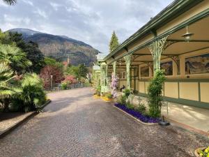 una strada di ciottoli di fronte a un edificio con piante di Darling Home a Merano