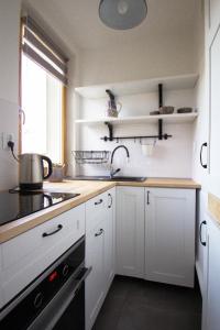 a kitchen with white cabinets and a sink at Signe Home in Gdańsk