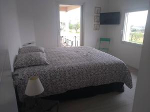 a bedroom with a bed and a lamp and a window at Maison moderne dans la drome des collines in Bren