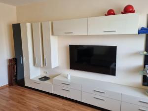 a living room with a tv and white cabinets at Danube Park in Ruse