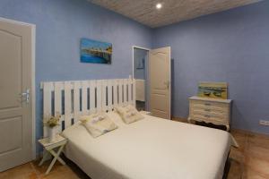 - une chambre avec un lit blanc et un mur bleu dans l'établissement Château Catherine de Montgolfier B&B, à Narbonne