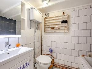 a bathroom with a toilet and a sink and a tub at Southview Cottages in Poynings