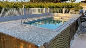 a swimming pool with a fence around it at Casa São Domingos in Salir de Matos