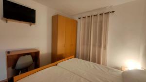 a bedroom with a bed and a desk and a television at Casa da Clarinha in Castelo de Paiva