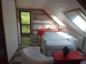 a attic room with a couch and a table at T3 ecolo en campagne in Le Roc-Saint-André