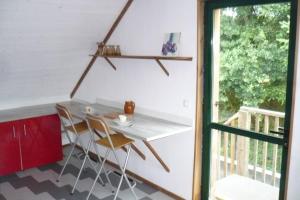 a table and chairs in a room with a balcony at T3 ecolo en campagne in Le Roc-Saint-André +17 photos
