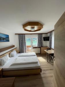 a bedroom with a large bed and a window at Hotel-Garni Seestrand in Zell am See