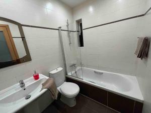 biała łazienka z toaletą i wanną w obiekcie A flat in the heart of bugibba w mieście St Paul's Bay