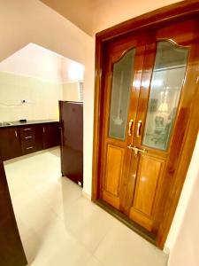 a kitchen with a wooden door and a refrigerator at Art House- Air conditioned luxury service Apartments in Bangalore