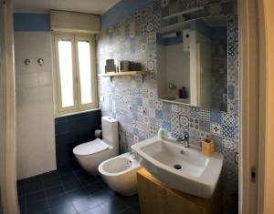 een blauwe en witte badkamer met een wastafel en een toilet bij la finestra sul mare a marzamemi in Marzamemi