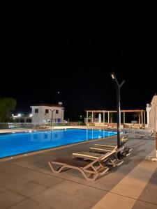 a swimming pool at night with lounge chairs and a light pole at Mountains and sea in Boghaz