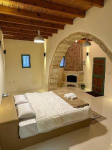 um quarto com uma cama grande e uma lareira de pedra em Tafileh-Sila'a Heritage Village em Tufailah