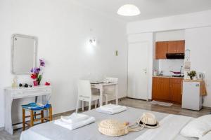 eine Küche und ein Wohnzimmer mit einem Tisch und einer Küche in der Unterkunft White wave studio 1 , 3min walk from Kamari beach in Kamari