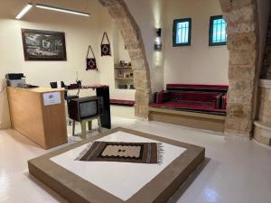 sala de estar con TV y sofá en una habitación en Tafileh-Sila'a Heritage Village en At-Tafilah