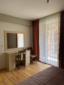 Summer Host Apartment Onegin في سوزوبول: غرفة نوم مع مكتب مع تلفزيون ونافذة