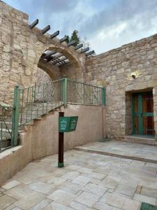 a stone building with a stairway and a gate at Tafileh-Sila'a Heritage Village in Tufailah