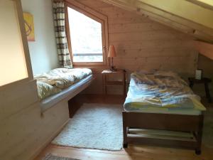 Schlafzimmer mit einem Bett und einem Fenster in der Unterkunft Les loulou in Savièse