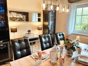 comedor con mesa y sillas de cuero en Panorama-Residenz, Pool, inkl ActivCard, en Bad Kötzting