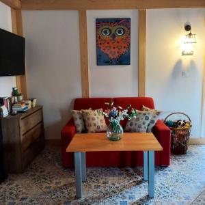 sala de estar con sofá rojo y mesa en Domek Sówka na Kociewiu 
