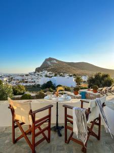 una mesa y sillas en un patio con vistas en Horizon Hotel en Chora Folegandros