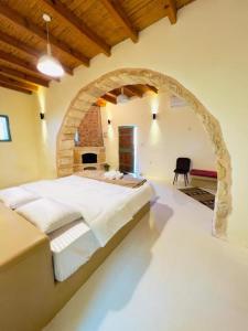 a bedroom with a large bed in a stone archway at Tafileh-Sila'a Heritage Village in Tufailah