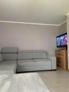 a living room with a couch and a flat screen tv at Dom na Mazurach in Stare Juchy