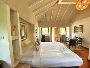 um quarto com uma grande cama branca num quarto em Katiliya Park Villa em Mae Chan