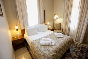 Una habitación de hotel con una cama con toallas. en The Colony Hotel en Haifa