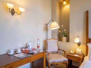 a room with a desk and a chair in a hotel room at The Colony Hotel in Haifa