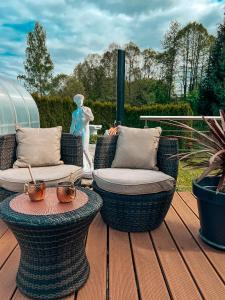 a patio with two chairs and a table on a deck at Panorama-Residenz, mit Pool in Bad Koetzting