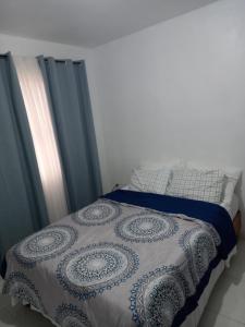een bed met een blauw en wit dekbed erop bij Casa amueblada a unos minutos del aeropuerto in Veracruz