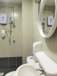 a bathroom with a sink and a mirror and two toilets at Emerald Avenue Cozy 3R3B Apartment 715 in Brinchang +22 photos