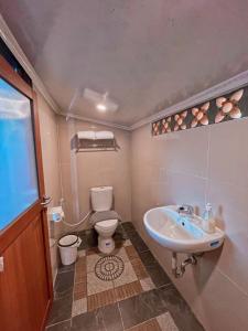 a bathroom with a toilet and a sink at De Pointé Resort & Resto in Campaka