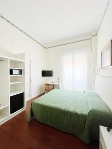 a bedroom with a green bed and a window at Hotel Piccadilly in Lido di Camaiore