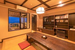 salon z drewnianym stołem i oknem w obiekcie Yuzanso w mieście Otsu